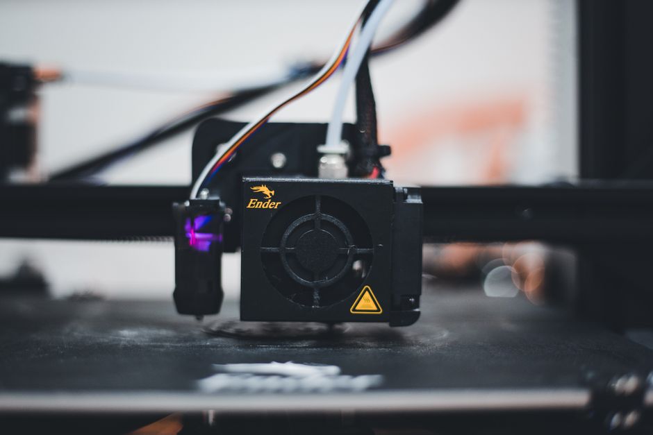Person inspecting a 3D printed part under bright light