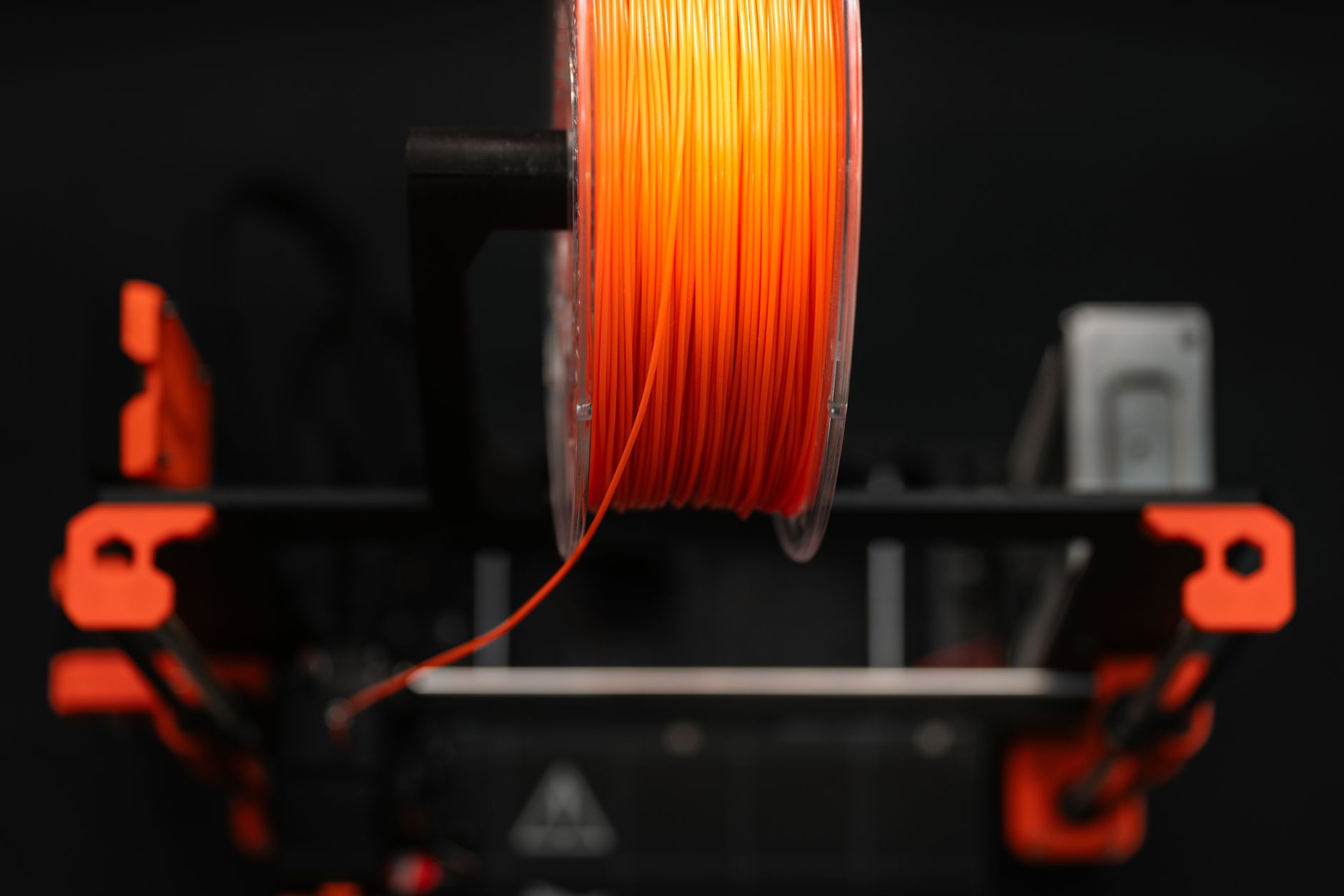 Rows of colorful 3D printer filament spools on a shelf