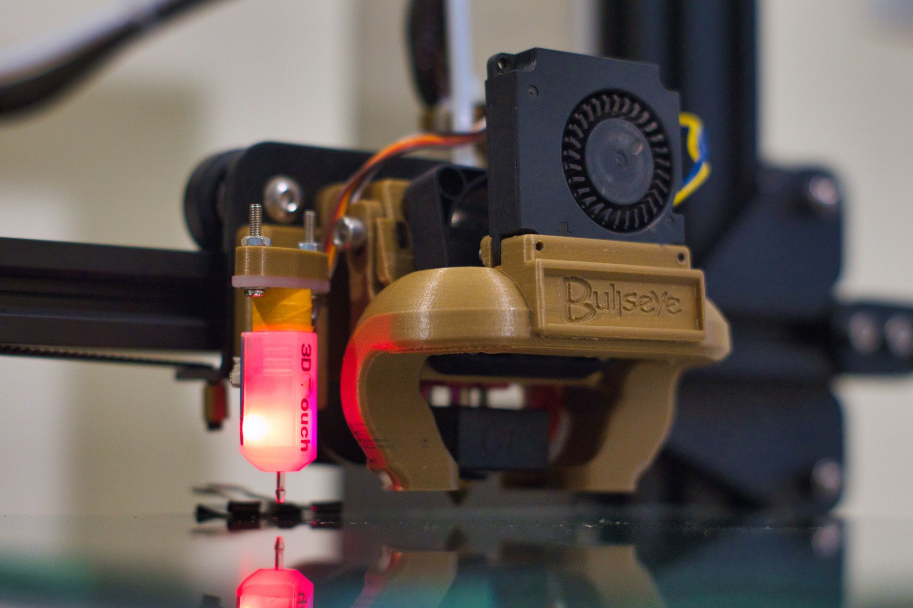 A small white calibration cube being printed on a 3D printer build plate